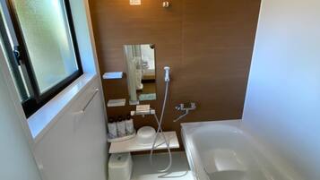 Tina con regadera, pantuflas, toallas