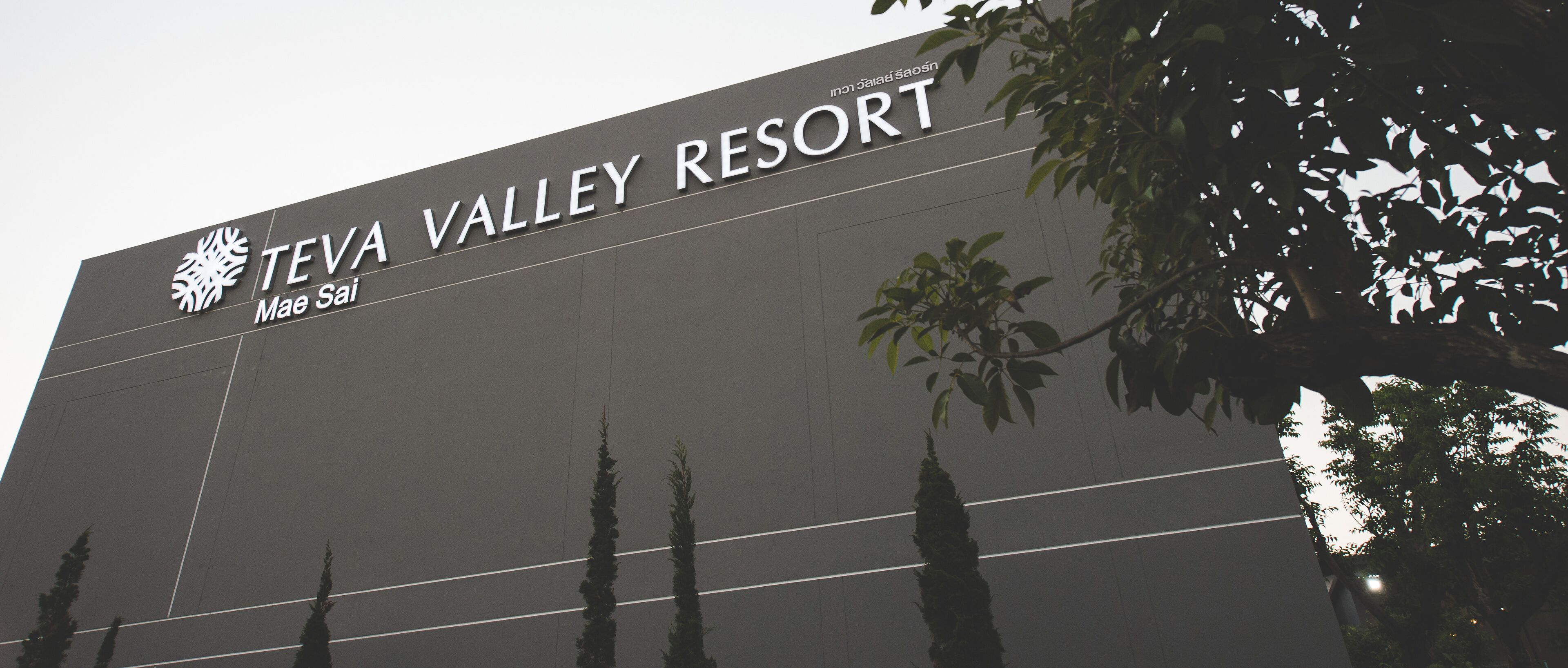 The exterior of Teva Valley Resort with a large sign and a modern architectural design.