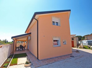 A single-story house with a covered patio, a small garden, and a gravel driveway. - Apartment 1332/12589 (Istria - Valbandon), 500m from the beach (Valbandon)