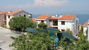 A residential area with terraced houses, a swimming pool, and a view of the sea.