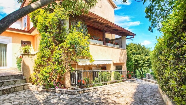 A two-story house with a stone-paved courtyard, a balcony with potted plants, and a clear blue sky. - Apartment 1346/12667 (Istria - Pula), 1000m from the beach (Pula)