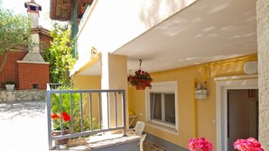 A building with a yellow exterior, a stone staircase leading to a door, and a hanging flower basket. - Apartment 1346/12667 (Istria - Pula), 1000m from the beach (Pula)