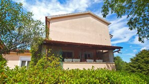 A two-story house with a balcony, surrounded by lush greenery. - Apartment 1346/12667 (Istria - Pula), 1000m from the beach (Pula)