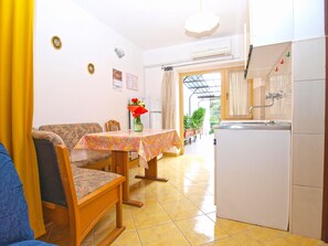 A compact kitchen with a dining area, a refrigerator, and a sink.