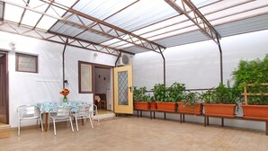 A covered patio area with a table and chairs, potted plants, and a door leading to an adjacent room. - Apartment 1348/12669 (Istria - Pula), 100m from the beach (Pula)