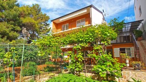 A two-story building with a balcony, surrounded by lush greenery and a garden. - Apartment 1348/12669 (Istria - Pula), 100m from the beach (Pula)