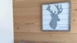 A framed deer head artwork with the word "HOME" on a wooden wall. - Turmalin 2. Stock by Interhome (Lenk)