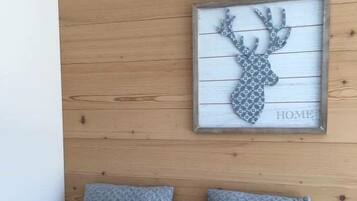 Ein gerahmtes Bild eines Rehgeweihs an einer Holzwand, mit dem Wort "HOME".