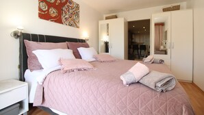A bedroom with a bed, pillows, a quilted bedspread, a nightstand, a wall art piece, and a wardrobe. - Apartment 1352/12718 (Istria - Pula), 750m from the beach (Pula)