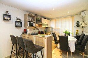 Una cucina compatta con zona pranzo, che comprende posti a sedere con uno sgabello da bar e un piccolo tavolo.