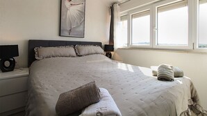 A bedroom with a large bed, a painting on the wall, and a window with curtains. - Apartment 1352/12722 (Istria - Pula), 750m from the beach (Pula)