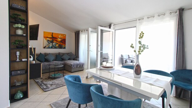 A modern living room with a sofa, a dining table, chairs, a bookshelf, and a painting. - Apartment 1352/12722 (Istria - Pula), 750m from the beach (Pula)