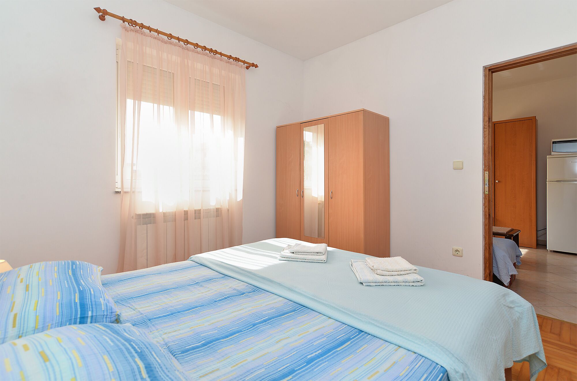 Une chambre à coucher avec un lit, une armoire et une vue sur la cuisine.