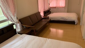 A bedroom with a bed, a sofa, and a window with curtains. - Resortstay in American village (Chatan)