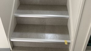 A staircase with a light-colored wall and a white handrail. - Resortstay in American village (Chatan)