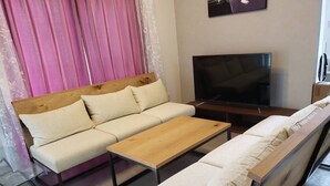 A modern living room with a sofa, a coffee table, and a TV. - Resortstay in American village (Chatan)