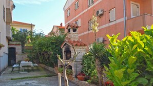 A courtyard with a stone-built oven, potted plants, and a table with chairs. - Studio apartment 1364/12839 (Istria - Pula), 2500m from the beach (Pula)