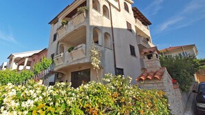 A multi-story building with balconies, a satellite dish, and a stone wall. - Studio apartment 1364/12839 (Istria - Pula), 2500m from the beach (Pula)