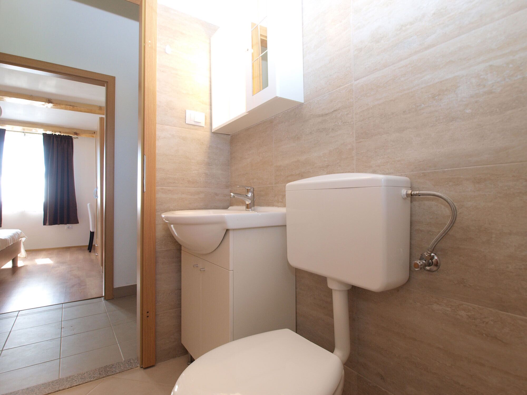 A bathroom with a toilet, sink, and shower.