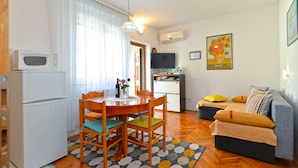 A compact living space with a dining area, kitchenette, and a sofa. - Apartment 1377/13010 (Istria - Poreč), 800m from the beach (Poreč)