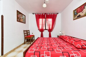 A bedroom with a bed, a chair, a nightstand, a lamp, and two paintings. - House 1378/12993 (Istria - Galižana), 7500m from the beach (Galižana)