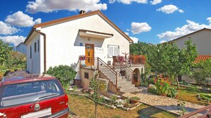 A two-story house with a white exterior, a wooden staircase, and a small garden with potted plants. - Apartment 1398/13153 (Istria - Pjescana Uvala), 350m from the beach (Pjescana Uvala)