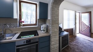 A kitchen with a built-in dishwasher, a coffee maker, and a window with a curtain. - Apartment 1398/13154 (Istria - Pjescana Uvala), 350m from the beach (Pjescana Uvala)