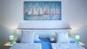 A bedroom with a bed, two bedside tables, and a painting of sailboats. - Apartment 1398/13155 (Istria - Pjescana Uvala), 350m from the beach (Pjescana Uvala)