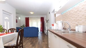 A modern kitchen with a wooden countertop, white cabinets, and a built-in sink.