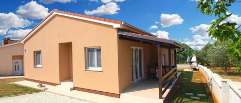 A two-story house with a flat roof and a covered porch.