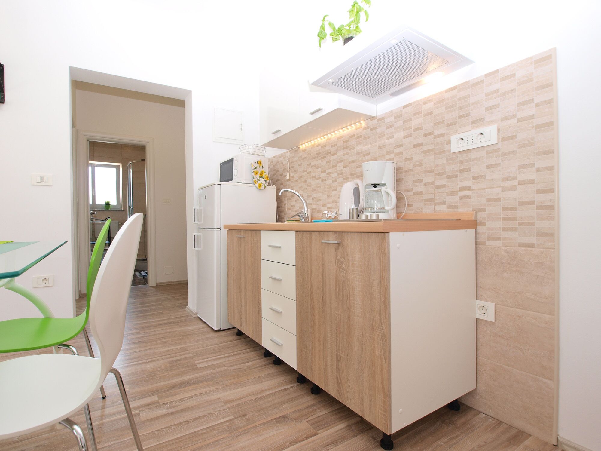 A modern kitchen with a wooden countertop, white appliances, and a tiled backsplash.