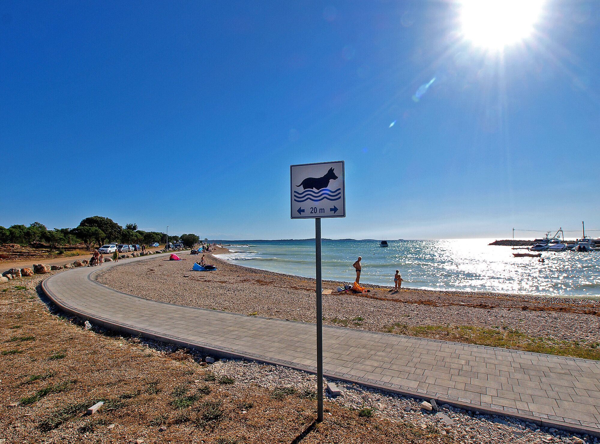 Une plage avec un panneau indiquant une distance de 20 mètres par rapport à la mer.