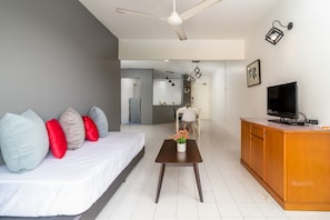 Quarto de hotel moderno com uma cama, uma escrivaninha de madeira, uma televisão e um ventilador de teto.