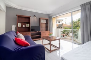 Relax in this stylish room with a comfortable sofa, flat-screen TV, and sliding glass door leading to a balcony with a view.