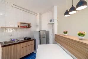 Enjoy cooking in this well-equipped kitchen with a stainless steel refrigerator, sink, and wooden cabinets.