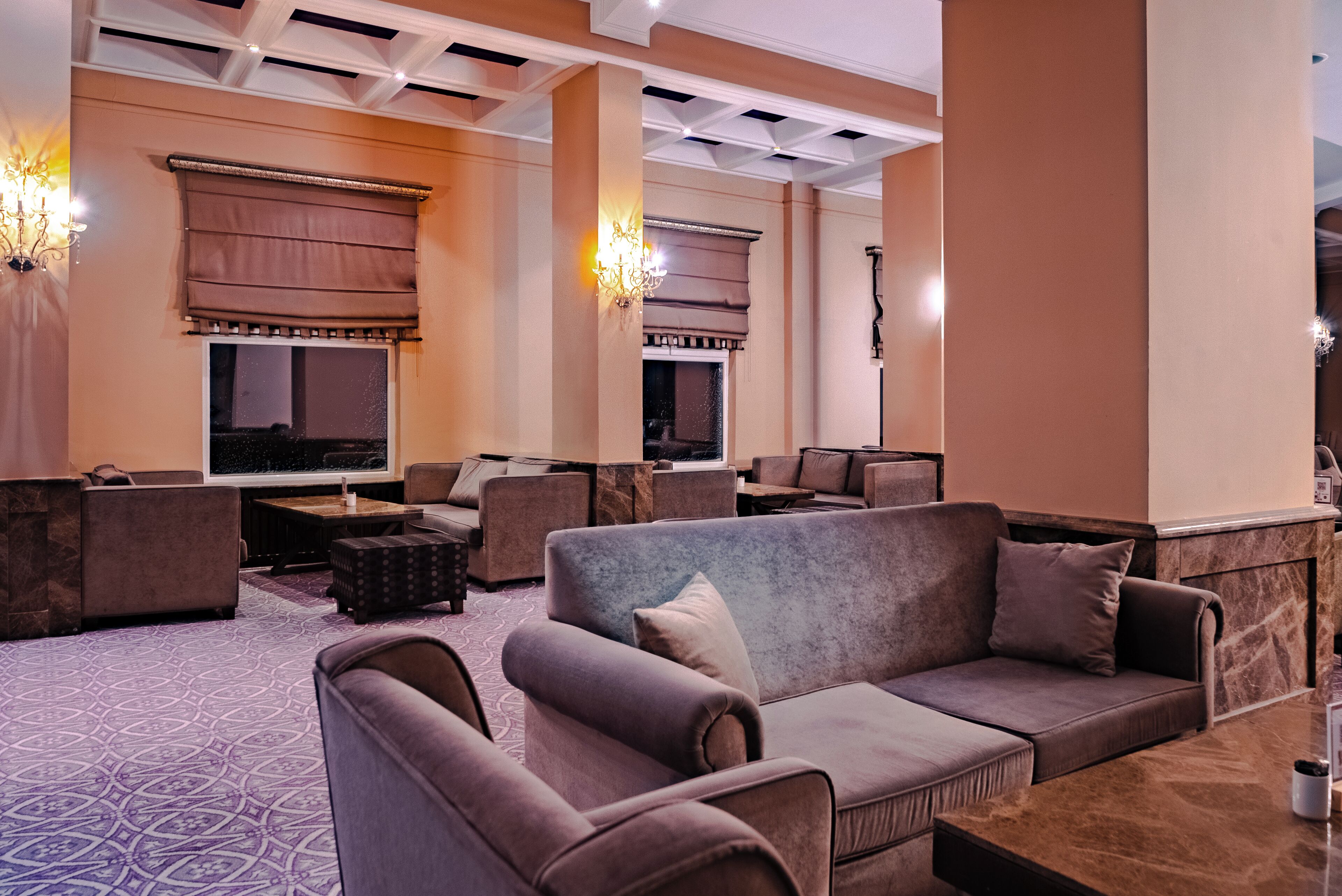 A modern lounge area with sofas, armchairs, and a fireplace.