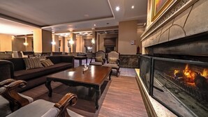 A spacious lounge area with a fireplace, comfortable seating, and a modern design. - Grand Yazıcı Uludağ (Bursa)