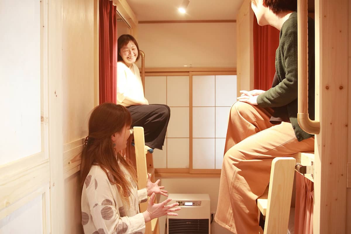 A narrow room with a bunk bed and a small heater.