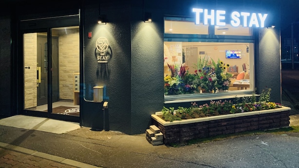 A hotel named "The Stay" with a visible entrance, a reception desk, and a window display of flowers. - The Stay Wakkanai- Hostel (Wakkanai)