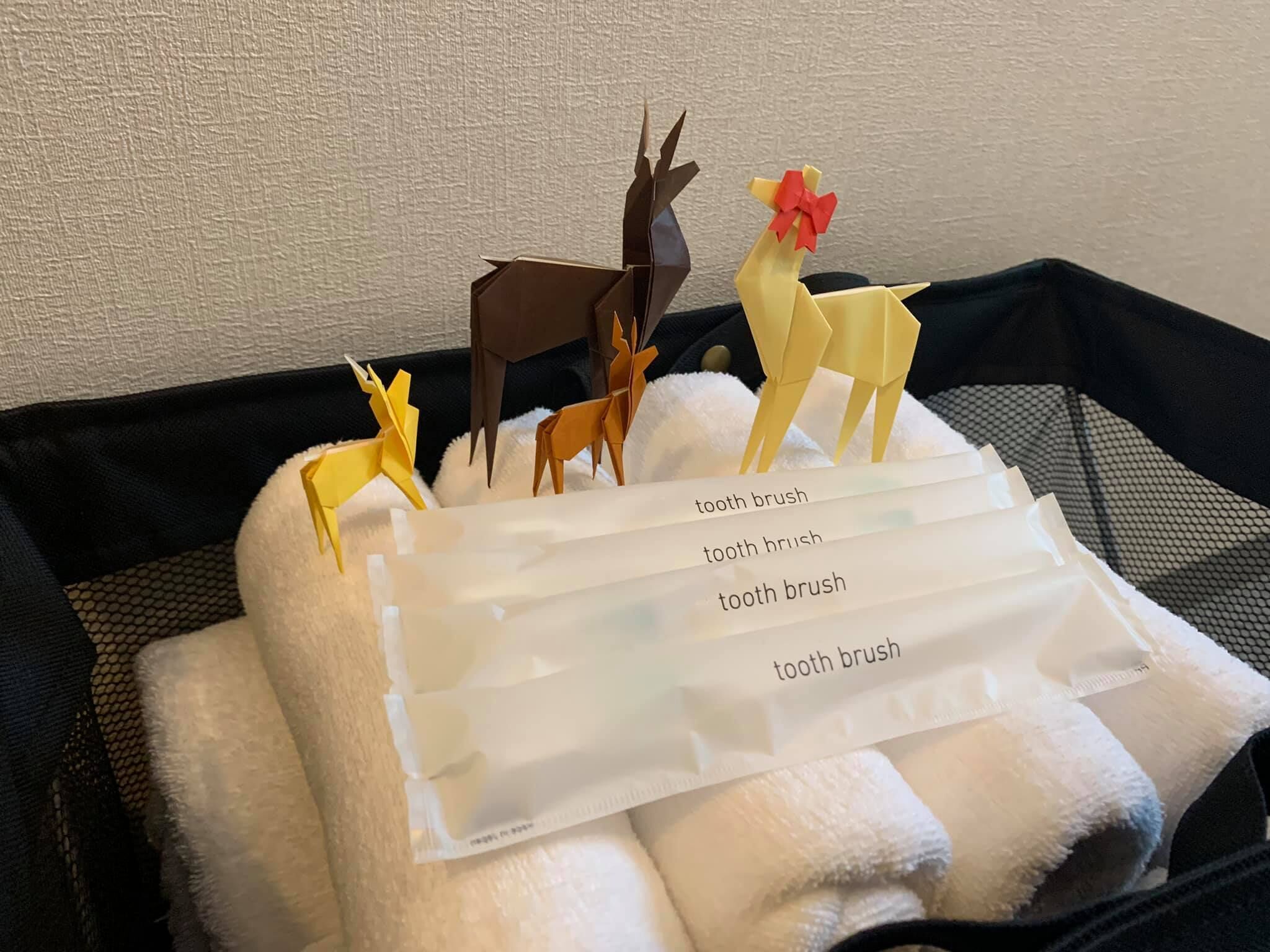Una bandeja con figuras de animales hechas con origami y varios cepillos de dientes.