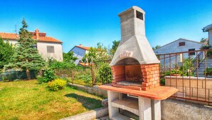 An outdoor brick pizza oven in a residential setting.