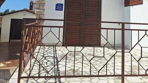 A two-story building with a white facade, a brown door, and a blue sign indicating an apartment. - Apartment 1453/13446 (Istria - Banjole), 100m from the beach (Banjole)