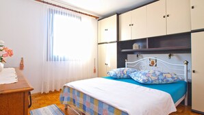 A bedroom with a bed, wooden desk, and a window with curtains. - House 1461/13494 (Istria - Pula), 4500m from the beach (Pula)