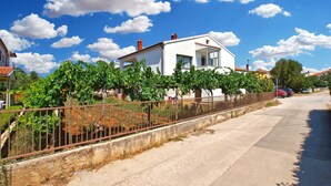 A residential area with a white house, a vineyard, and a clear blue sky. - Apartment 1468/13511 (Istria - Fažana), 300m from the beach (Fažana)