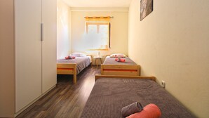 A narrow room with two single beds, a small table with a lamp, and a window with curtains. - Apartment 1468/13511 (Istria - Fažana), 300m from the beach (Fažana)