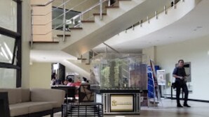 Un vestíbulo amplio con una escalera moderna, una zona de estar y un ventanal grande.