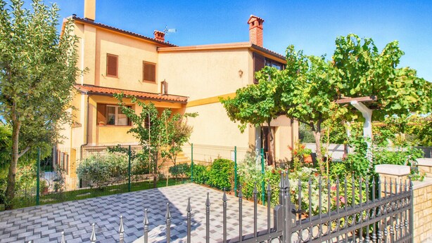A two-story house with a tiled patio and a metal fence. - Apartment 1482/13875 (Istria - Medulin), 600m from the beach (Medulin)