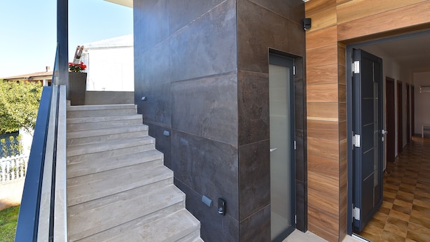 A modern staircase with a dark wall and a wooden panel on the right. - Apartment 1490/14261 (Istria - Fažana), 350m from the beach (Fažana)
