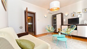 A living room with a sofa, two chairs, a TV, and a dining table. - Apartment 1490/14261 (Istria - Fažana), 350m from the beach (Fažana)