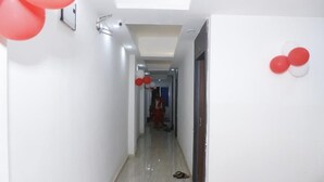 Un pasillo con una lámpara en el techo, una puerta y un par de pantuflas en el suelo.